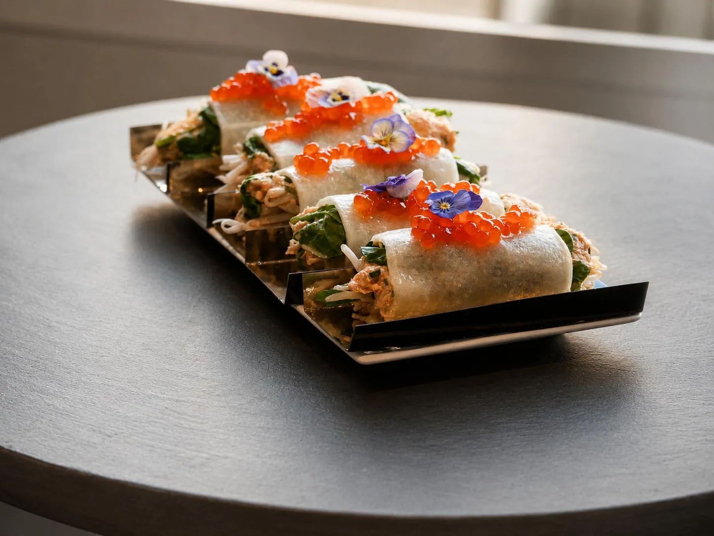 Formule de la semaine : rouleaux de printemps au tourteau, œufs de saumon et fleurs comestibles, préparés par la maison traiteur gastronomique Les Temps Gourmands à Pont-l'Abbé (Pays Bigouden)