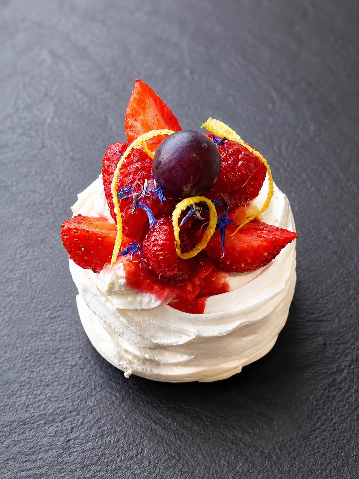 Pavlova aux fraises, framboises, zestes de citron et fleurs comestibles — dessert maison du traiteur Les Temps Gourmands à Pont-l'Abbé, Pays Bigouden